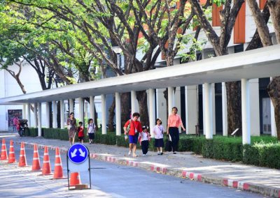 Kids and parent using the cover way to commute within campus.